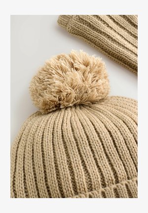 Cappello lavorato a maglia beige con un motivo a coste, dotato di un morbido pon-pon sulla parte superiore. Texture soffice e materiale caldo adatto per il clima freddo.