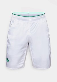 Balti sportiniai šortai su žalia juosta ir žalia Adidas trefoil logotipu. Pagaminti iš lygaus, lengvo audinio, su šoninėmis kišenėmis.