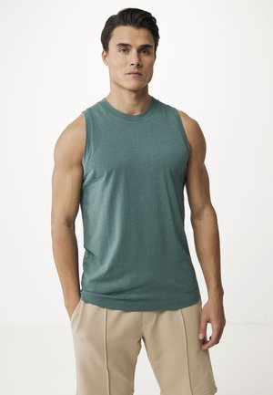 Groene mouwloze T-shirt van zachte stof, met een ronde halslijn en een relaxte pasvorm, gecombineerd met beige shorts.