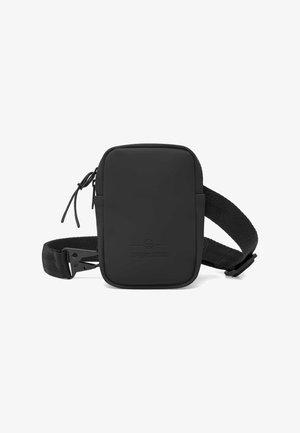 Černá obdélníková sling bag vyrobená z hladkého materiálu, vybavená zipovým uzávěrem, nastavitelným textilním popruhem a reliéfním logo na přední straně.