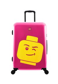Pink hard-shell luggage with a yellow LEGO figure design, featuring a telescoping handle, four black wheels, and a LEGO logo.