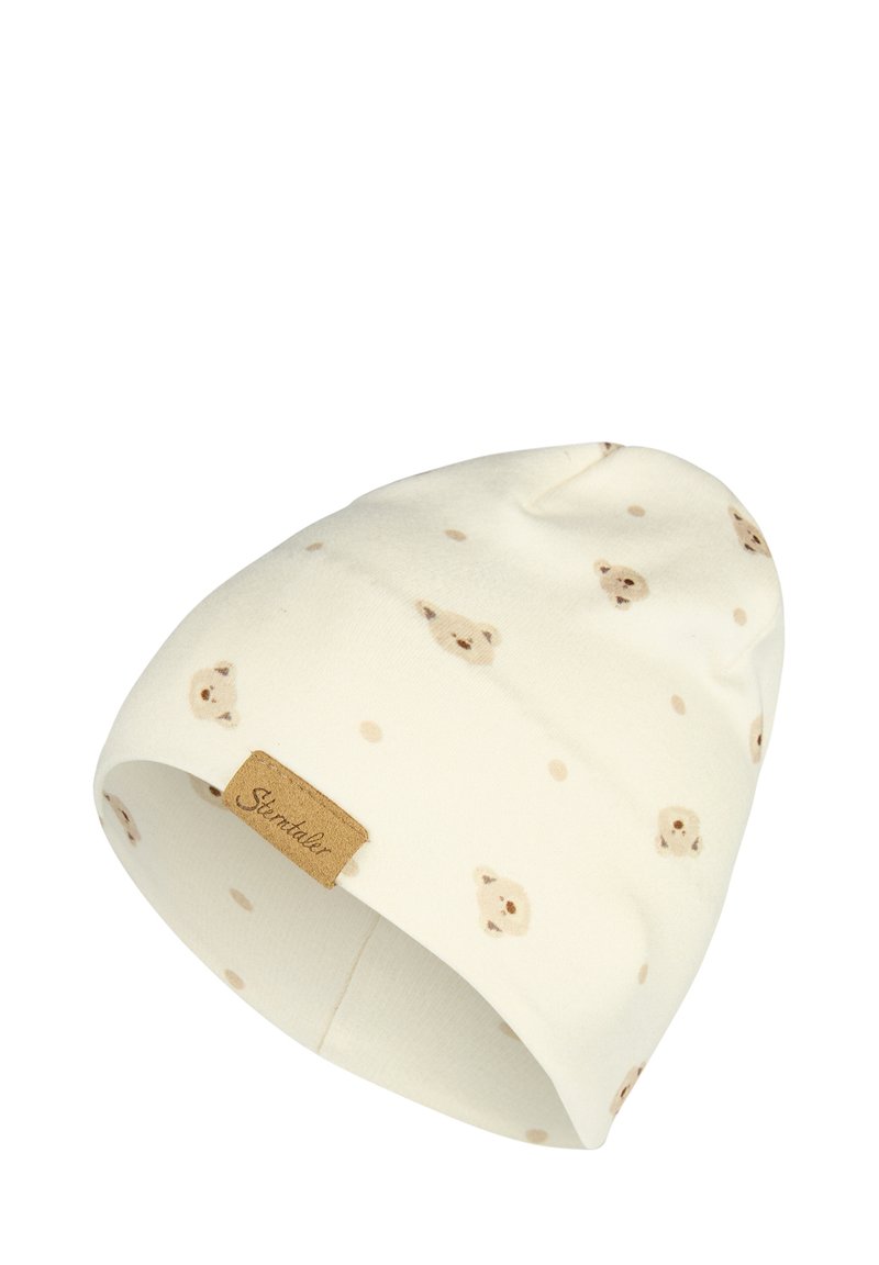 White knit beanie featuring a pattern of light brown bear faces and beige dots, with a small brown label on the cuff.