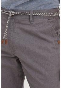 Grå tygshorts med en texturerad yta, med framfickor, en flätad dragsko och bruna läderdetaljer.