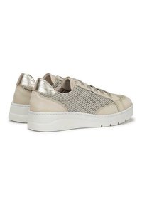 Zapatillas de sport de color beige claro con detalles metálicos, paneles de malla y una suela blanca gruesa. La puntera redondeada y los cordones planos realzan el diseño deportivo.