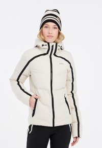 Puffjakke i lys creme med sort trim og lynlåsdetaljer. Har hætte og lommer. Struktureret stof med quiltet design.
