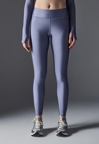 Høyt liv, tettsittende leggings i lys lilla, laget av et glatt, elastisk stoff. Har en sømløs design og subtile sømdetaljer.