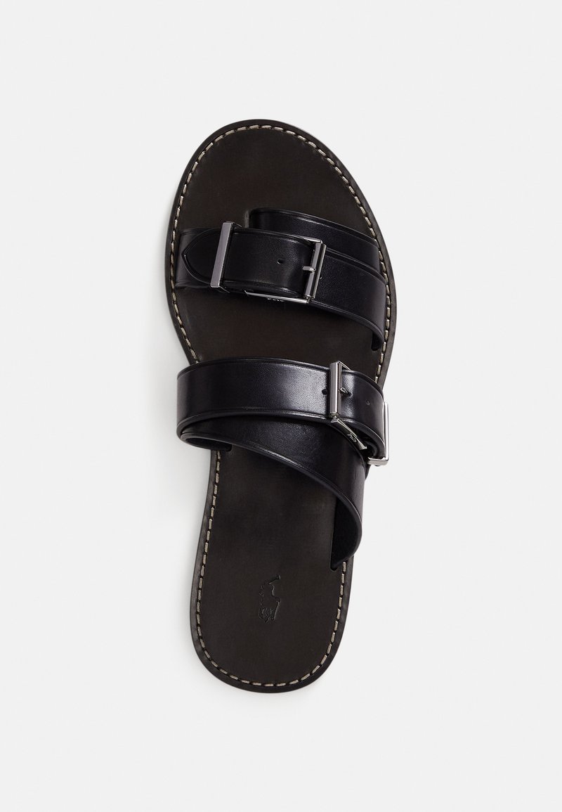 Black leather sandal with two overlapping straps and a buckle. Textured footbed with light stitching along the edge. Flat sole.