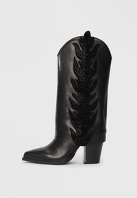 Black leather cowboy boot with a pointed toe, embellished with a leaf pattern in black rhinestones on the shaft. Chunky block heel.