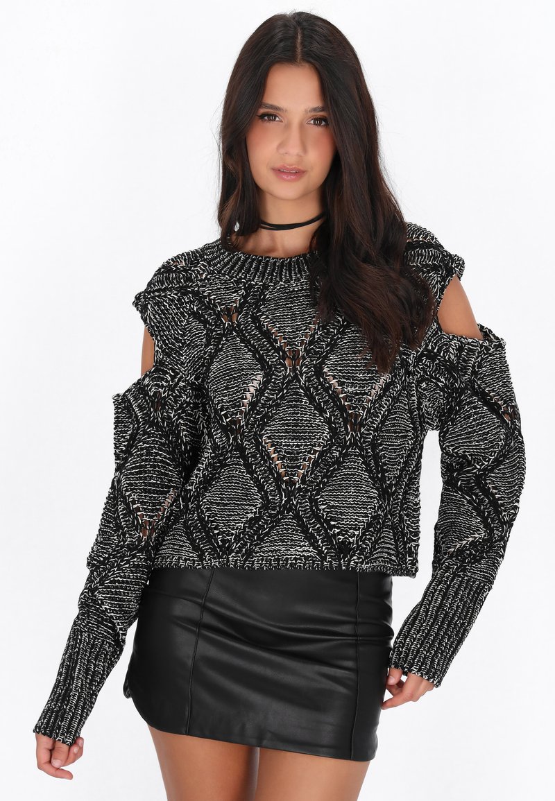 Maglione bianco e nero con spalle scoperte e un motivo a rombi testurizzato. Presenta maniche lunghe e un design corto. Abbina a una gonna di pelle nera.