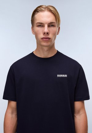 Navy blue cotton t-shirt with short sleeves, featuring a small white logo on the left chest area. Soft texture with a classic fit.
