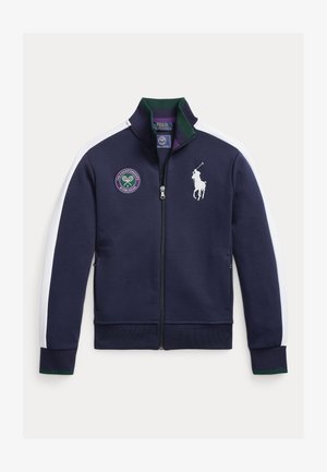 Tumesinine lukuga jope valgete küljeribadega, millel on roheline ja lilla tennisemärk ning valge polo mängija logo. Valmistatud pehmest kangast.