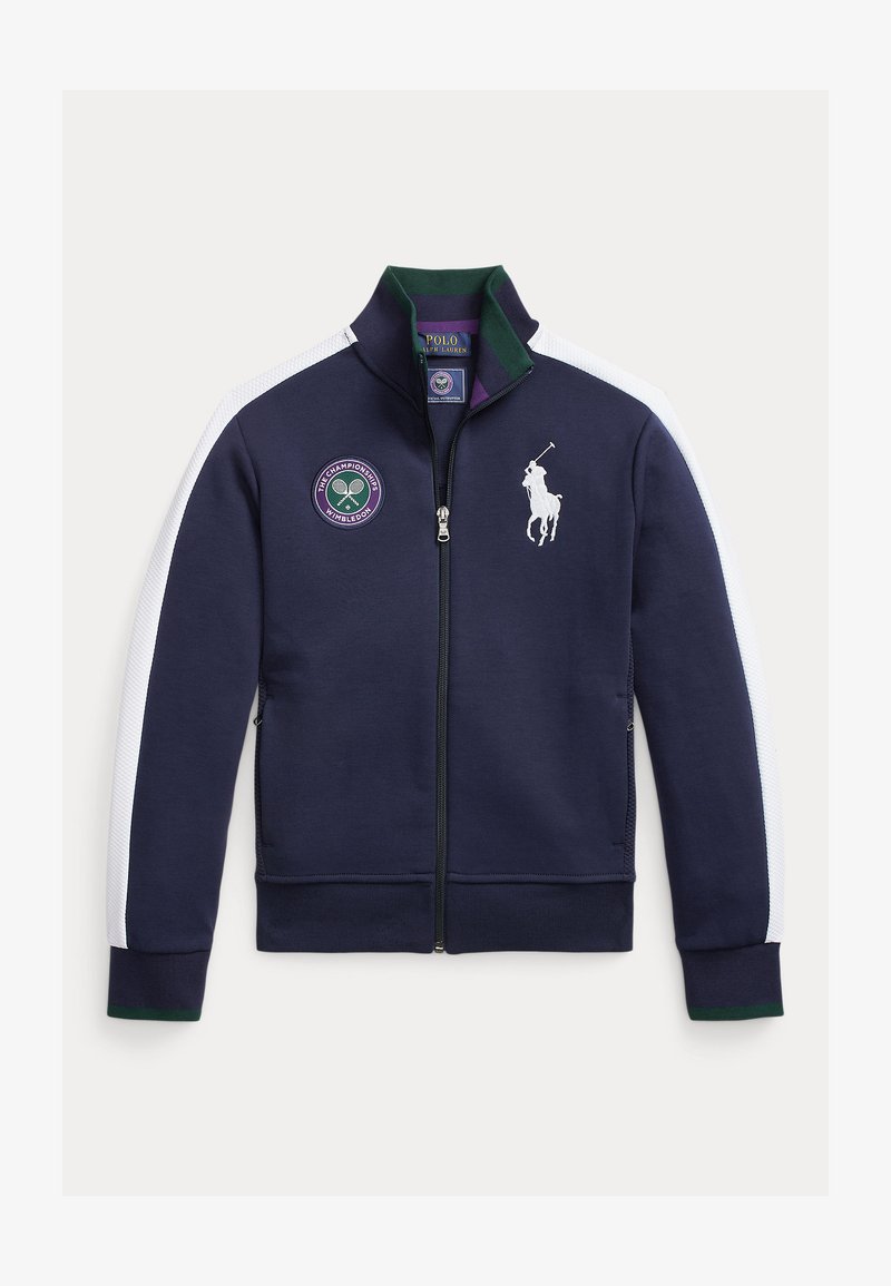 Temno modra jakna na zadrgo z belimi stranskimi proge, zeleni in vijolični tenis obliž ter bel logotip polo igralca. Iz mehke tkanine.