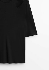 T-shirt nero a maniche corte con texture a coste, caratterizzato da un dettaglio a taglio sulla spalla e un collo rotondo.