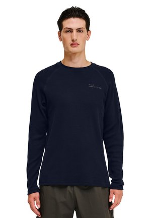 Marineblå langærmet skjorte lavet af struktureret stof med raglanærmer, der har et lille logo på brystet. Lige skåret kant.