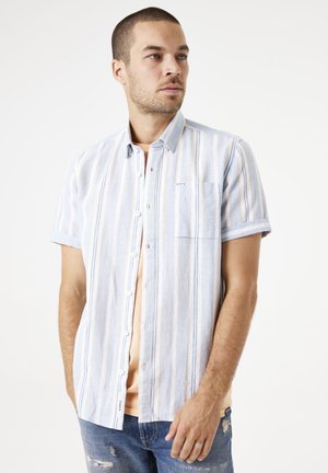 Camisa de manga corta azul claro con rayas verticales en blanco y colores pastel, que cuenta con un bolsillo en el pecho y un cierre de botones en la parte delantera.