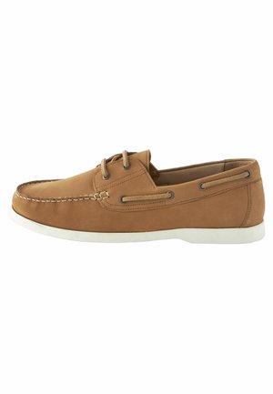 Zapato náutico de cuero marrón con un diseño elegante, suela de goma blanca, cordones delgados y detalle de costura a lo largo del borde.