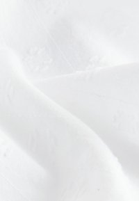 Tissu blanc avec un motif texturé subtil, tissé serré, finition lisse et qualité légèrement réfléchissante, créant une apparence douce et élégante.