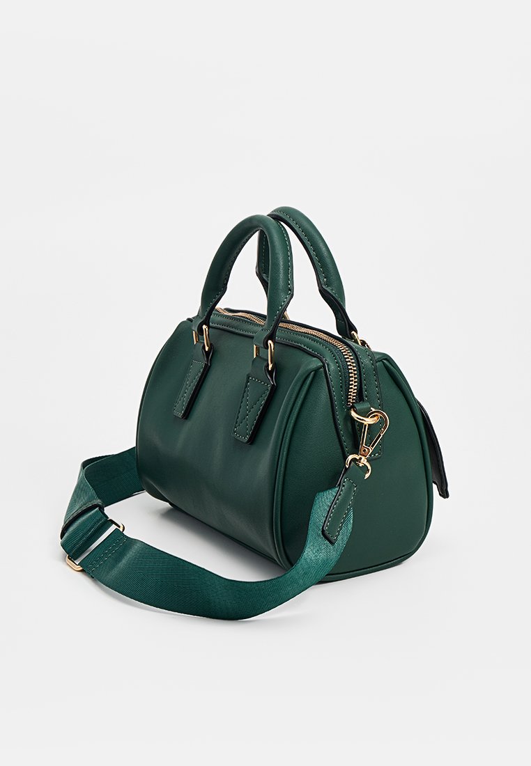 Borsa in pelle verde con forma arrotondata, doppi manici corti e una tracolla removibile. Presenta una cerniera dorata e dettagli di cucitura delicati.