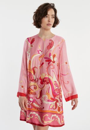 Langdurige mouwen, roze zijde jurk met een levendig bloemenpatroon in rood en oranje. Heeft een ronde halslijn en een contrasterende rode zoom.