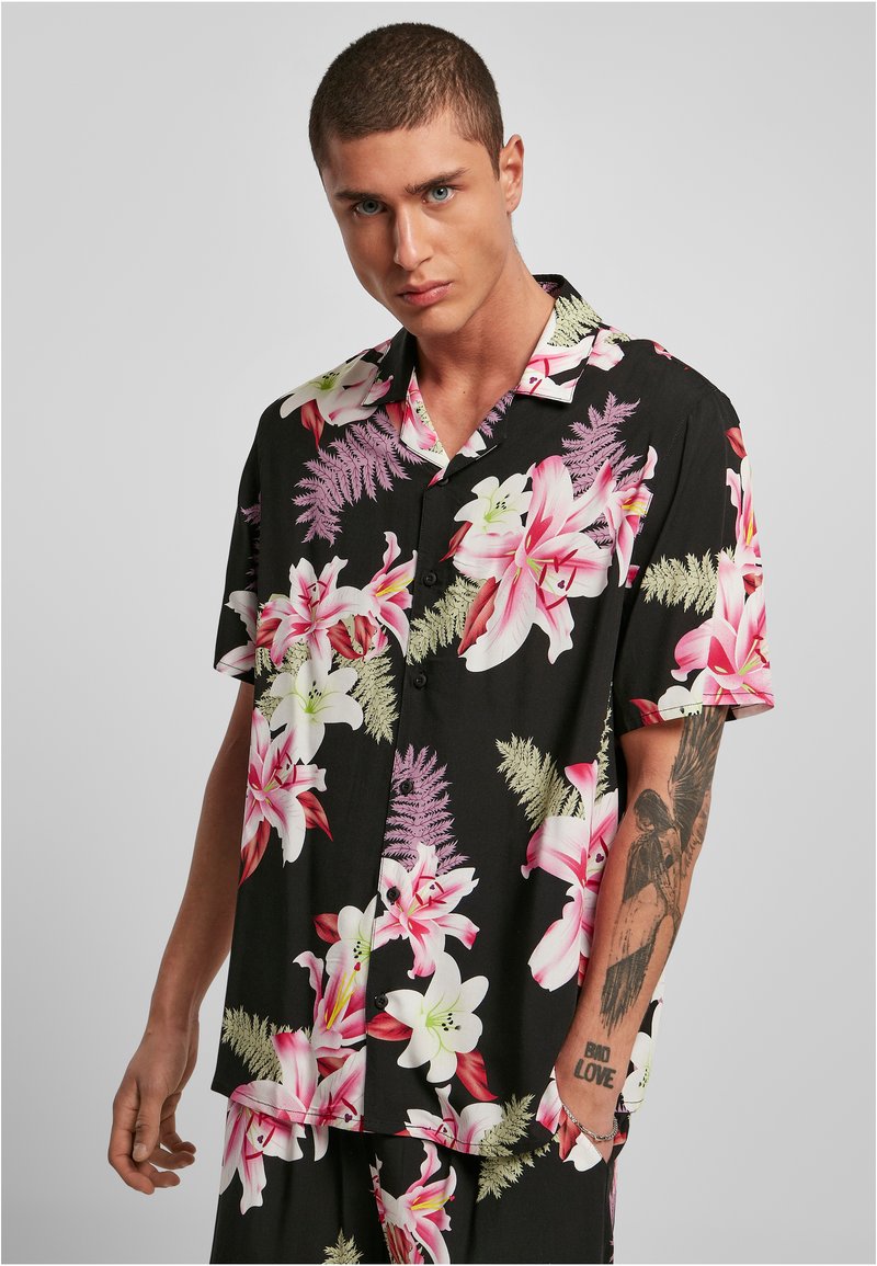 Cămașă neagră cu mânecă scurtă, cu un model floral ce prezintă crini mari roz și albi, cu accente verzi, design cu guler și închidere cu butoane.