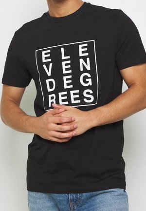 Czarny T-shirt z białą kwadratową grafiką, na której widoczne są pionowo i poziomo ułożone litery tworzące słowo "ELEVEN DEGREES."