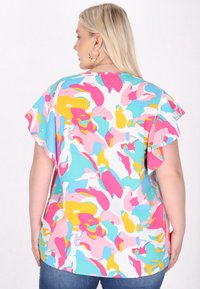 Farverig kortærmet bluse med et abstrakt mønster i pink, blå, gul og hvid, med en afslappet pasform og blød stoftekstur.