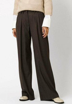 High-waisted, wide-leg trousers in dark brown fabric, featuring front pleats and a tailored fit, paired with a light sweater and shoes.