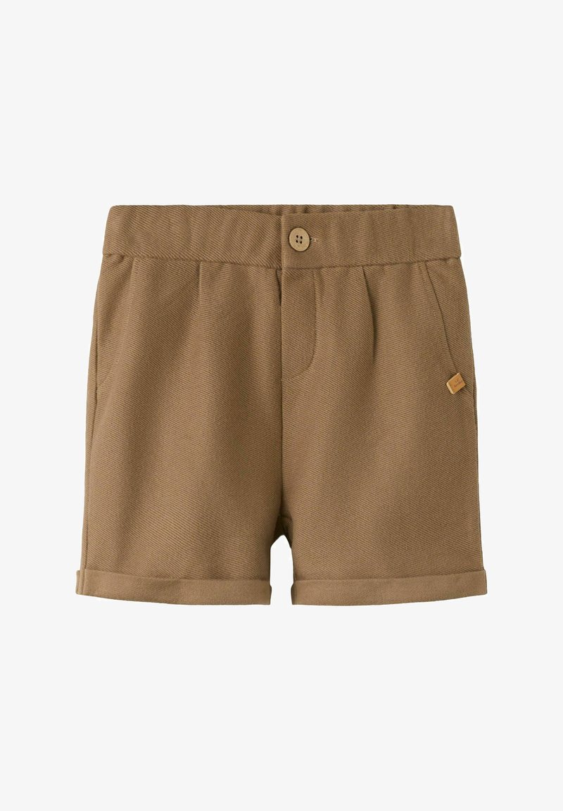 Shorts marron sur mesure avec fermeture à bouton, plis, poches latérales, ourlets retroussés et une petite étiquette logo carrée sur la poche droite.