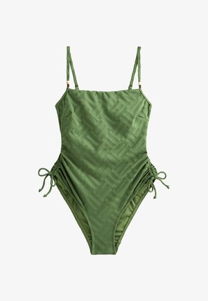 Zielony jednoczęściowy kostium kąpielowy z teksturowanym wzorem, regulowanymi ramiączkami i bocznym marszczeniem dla lepszego dopasowania. Gładki materiał, minimalistyczny design.