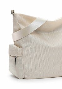 Beige textured fabric bag with a wide, smooth strap and a zippered pocket on the side. Features a geometric pattern and metallic accents.