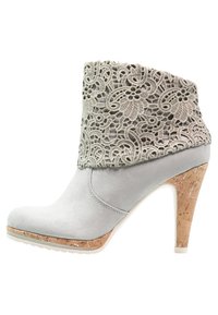 Gray suede ankle boot with a lace overlay at the cuff, cork heel, and white sole. Features a rounded toe and a slender heel.