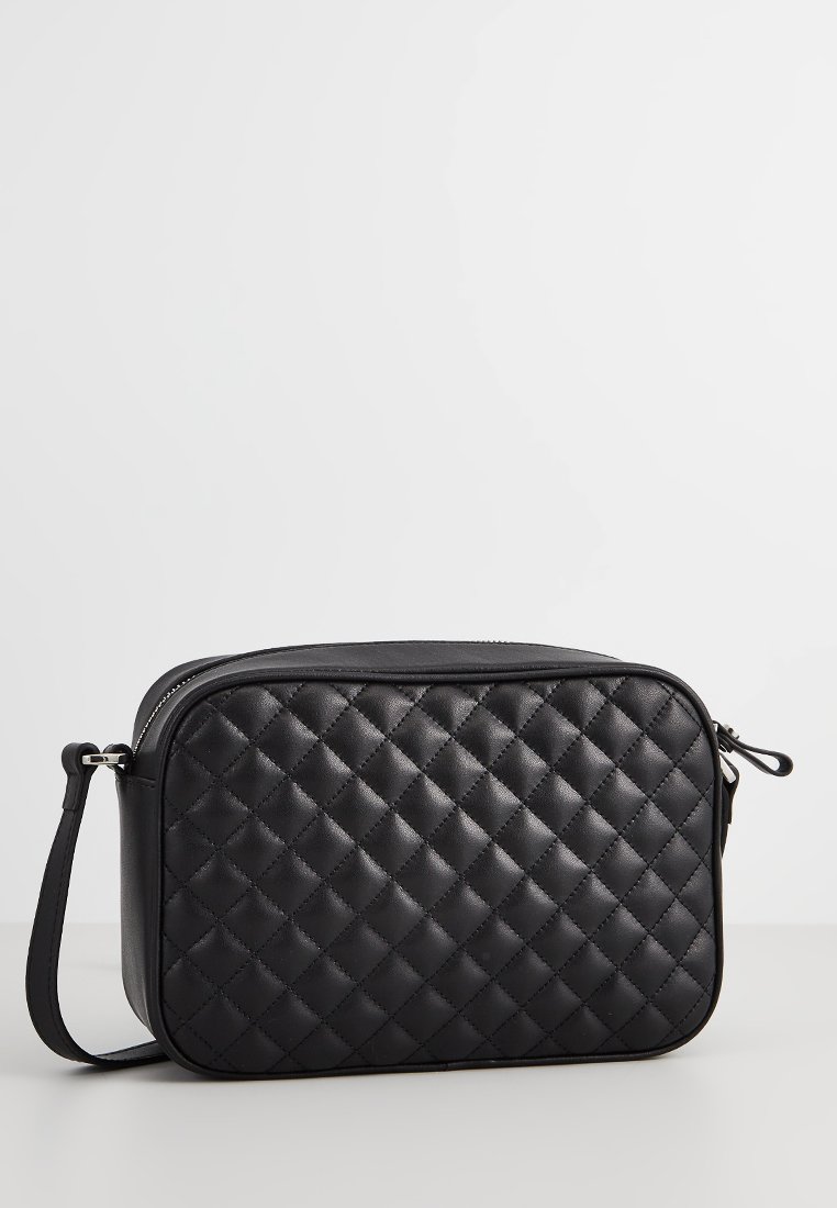 Schwarze gesteppte Ledertasche in Kreuzbody-Form mit rechteckiger Form, Reißverschluss und verstellbarem Tragegurt. Auffälliges Rautenmuster auf der Oberfläche.