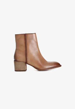 Stivaletto in pelle marrone con punta tondeggiante, pannello laterale testurizzato e tacco in legno impilato. Superficie liscia con un leggero lucido.