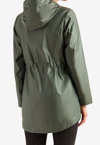 Zielona, lekka kurtka z kapturem, taliowana w pasie, o gładkiej, lekko pomarszczonej fakturze. Posiada prosty krój i dłuższy tył.