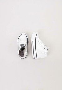 Zapatillas de lona altas y bajas blancas con acentos negros, suela de goma, punta redonda y cordones, con una cremallera en la parte alta.