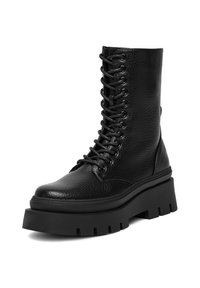 Czarne skórzane botki za kostkę z teksturowanym wykończeniem, sznurowanym przodem oraz grubą, gumową podeszwą z głębokimi szczelinami i zaokrąglonym czubkiem.