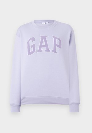 Lys lilla genser med rund hals og lange ermer, med stor teksturert "GAP" logo på brystet i matchende lilla toner.