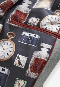 Pañuelo de bolsillo con una tela gris texturizada que presenta impresiones de relojes vintage, cámaras, decantadores de vidrio y sellos decorativos.