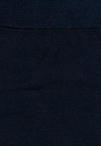Tela de punto azul marino con una textura suave, que presenta un sutil patrón en relieve que dice "XO" cerca del borde superior.