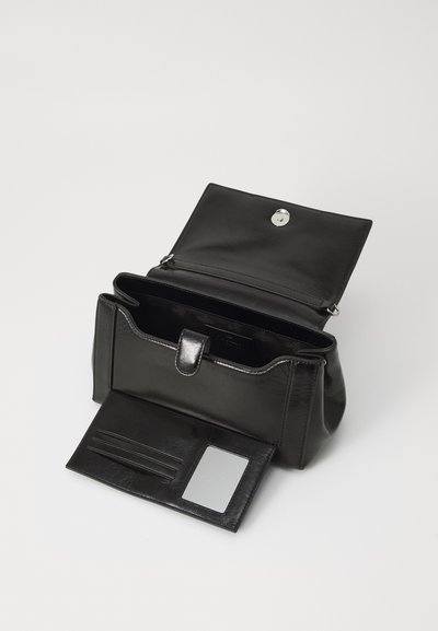 Black leather handbag with a flap closure, interior compartments, and card slots. Textured finish and shiny metallic snap button detail.