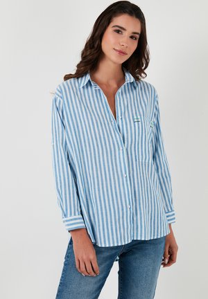Blue and white striped button-up shirt made of lightweight fabric, featuring long sleeves, a chest pocket, and contrasting sewn accents.