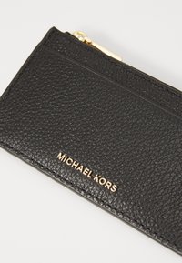 Black leather wallet with a textured finish, featuring a gold logo, zip closure, and card slots on one side. Compact and functional design.