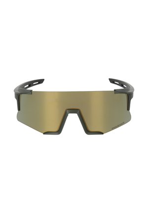 Jeune homme portant de grandes lunettes de sport angulaires à verres teintés jaunes et un t-shirt vert olive avec l'inscription « ENDURANCE » sur la poitrine.