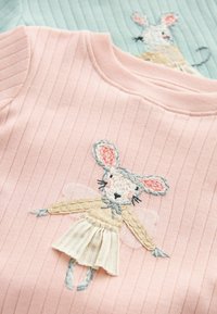 Rosa geripptes Oberteil mit einem gestickten Maus-Charakter in sanften Pastellfarben, der ein beiges Kleid und einen blauen Schal trägt.