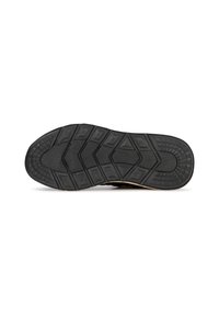 Semelle de chaussure en caoutchouc noir avec une adhérence en relief, présentant un design de semelle géométrique et des bords lisses pour une traction et une durabilité optimales.