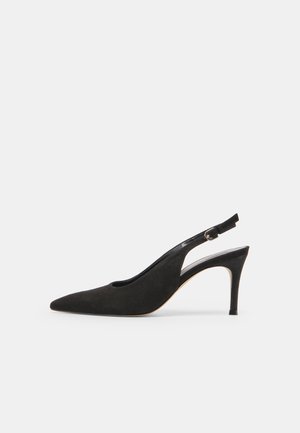 Sort ruskind slingback højhælet sko med spids tå og justerbar spænde, vist i sideprofil på hvid baggrund.