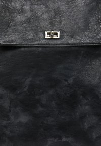 Bolso de cuero negro con una superficie texturizada, un cierre metálico plateado y un diseño minimalista con tapa.