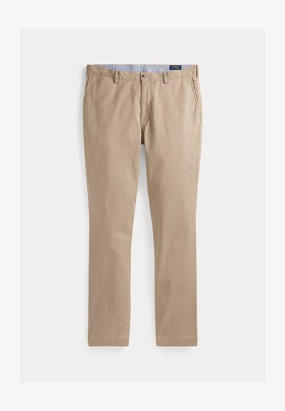 Beżowe, dopasowane, casualowe spodnie z szlufkami na pasek, guzikiem z przodu, zamkiem błyskawicznym, bocznymi kieszeniami oraz metką "Polo Ralph Lauren" na podszewce pasa.