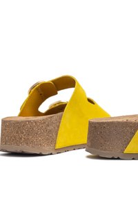 Sandales compensées en daim jaune avec plateforme en liège, dotées d'un design découpé et d'une boucle ajustable. Semelle texturée pour une meilleure adhérence.