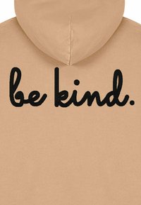 Felpa con cappuccio beige chiaro, con testo ricamato nero "be kind." posizionato sul retro, caratterizzata da una texture liscia e un design non strutturato.
